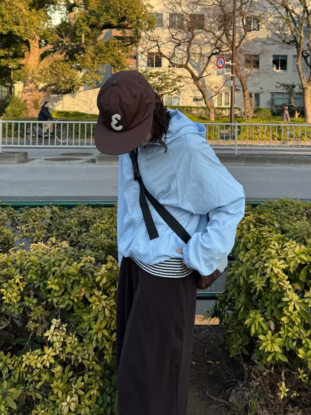 ブラウン系のボディバッグ/ウエストポーチ、ブラック系のスニーカー、ホワイト系のTシャツ/カットソーを着用したレディースの冬コーディネートの3枚目の写真