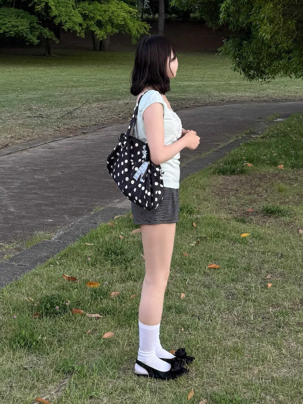 ブラック系のパンツ、ブラック系のバッグ、ブラック系のパンプスを着用したレディースの春コーディネートの2枚目の写真