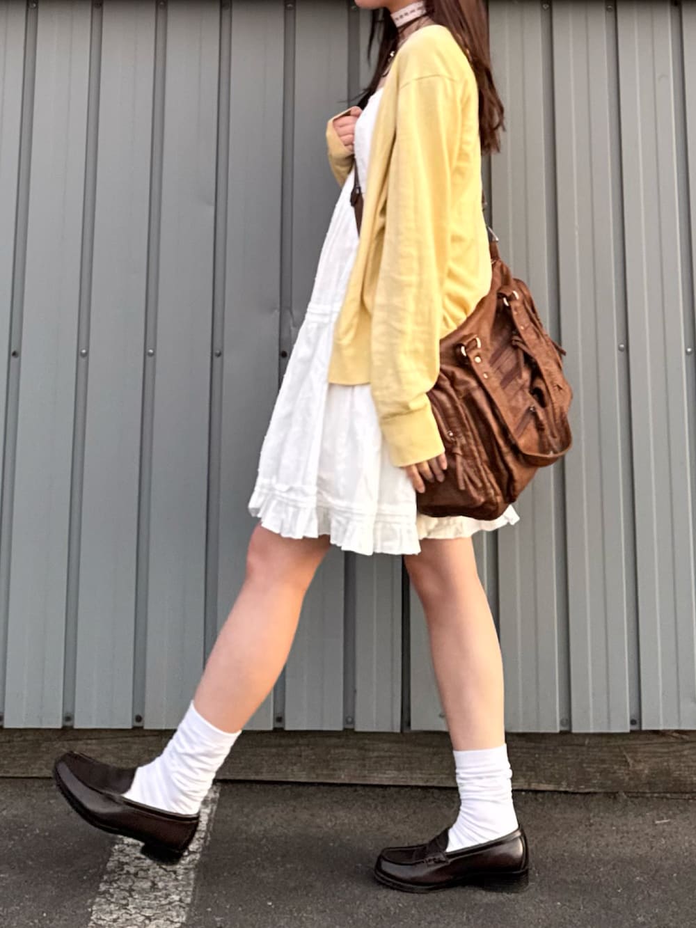 ホワイト系のワンピース、ブラウン系のローファー、イエロー系のカーディガン/ボレロを着用したレディースの秋コーディネートの2枚目の写真
