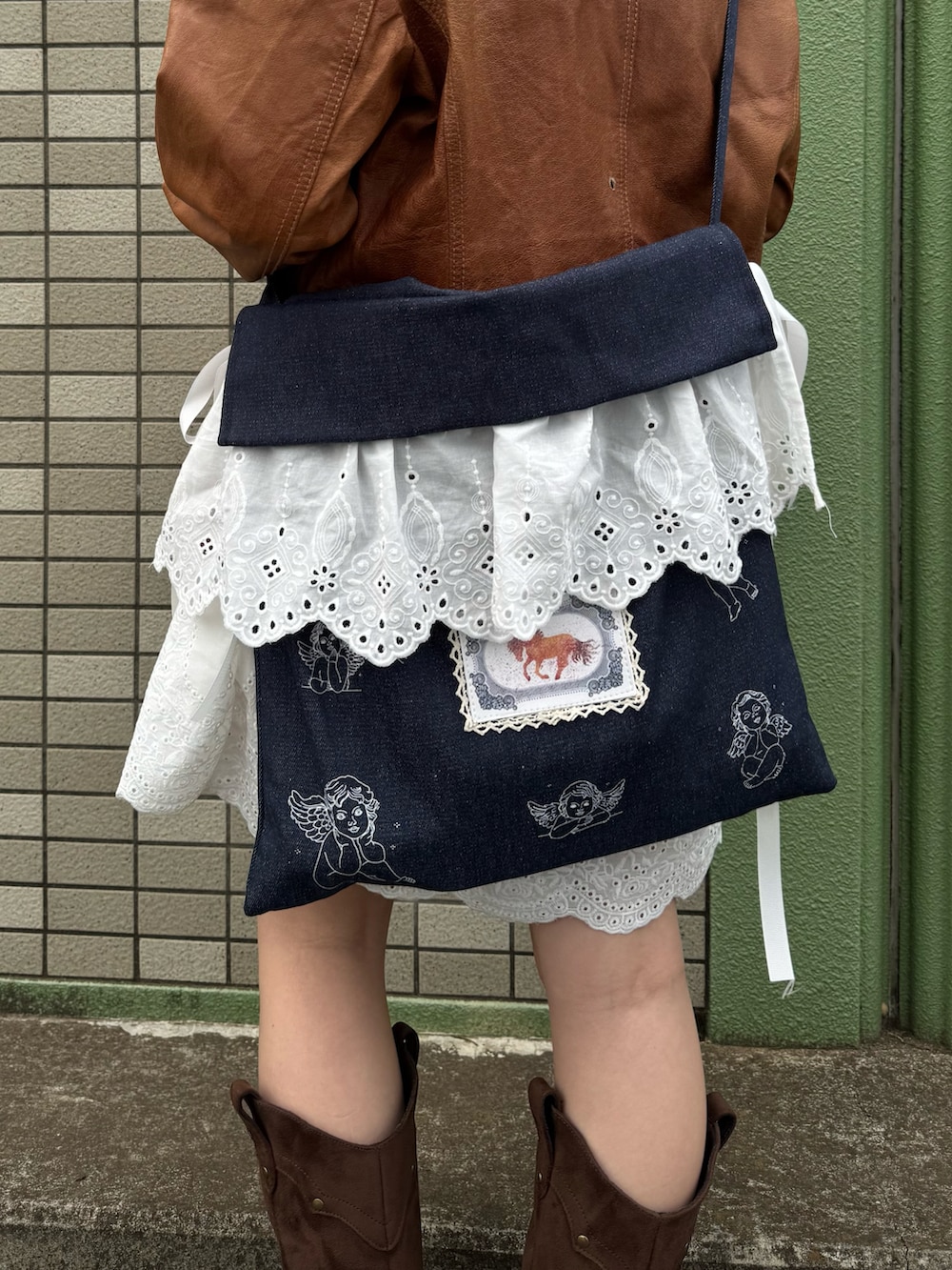 ホワイト系のワンピース、ブルー系のショルダーバッグを着用したレディースの冬コーディネートの2枚目の写真