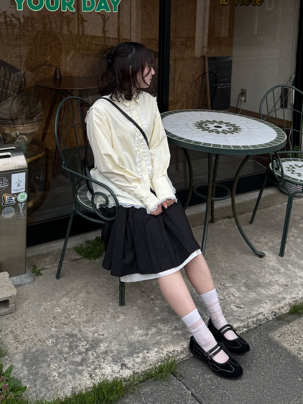 ブラック系のスカート、ブラック系のスニーカー、イエロー系のシャツ/ブラウスを着用したレディースの春コーディネートの3枚目の写真