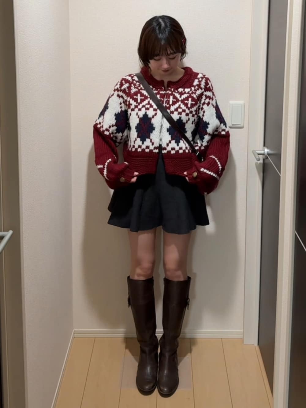 レッド系のカーディガン/ボレロを着用したレディースの冬コーディネートの2枚目の写真