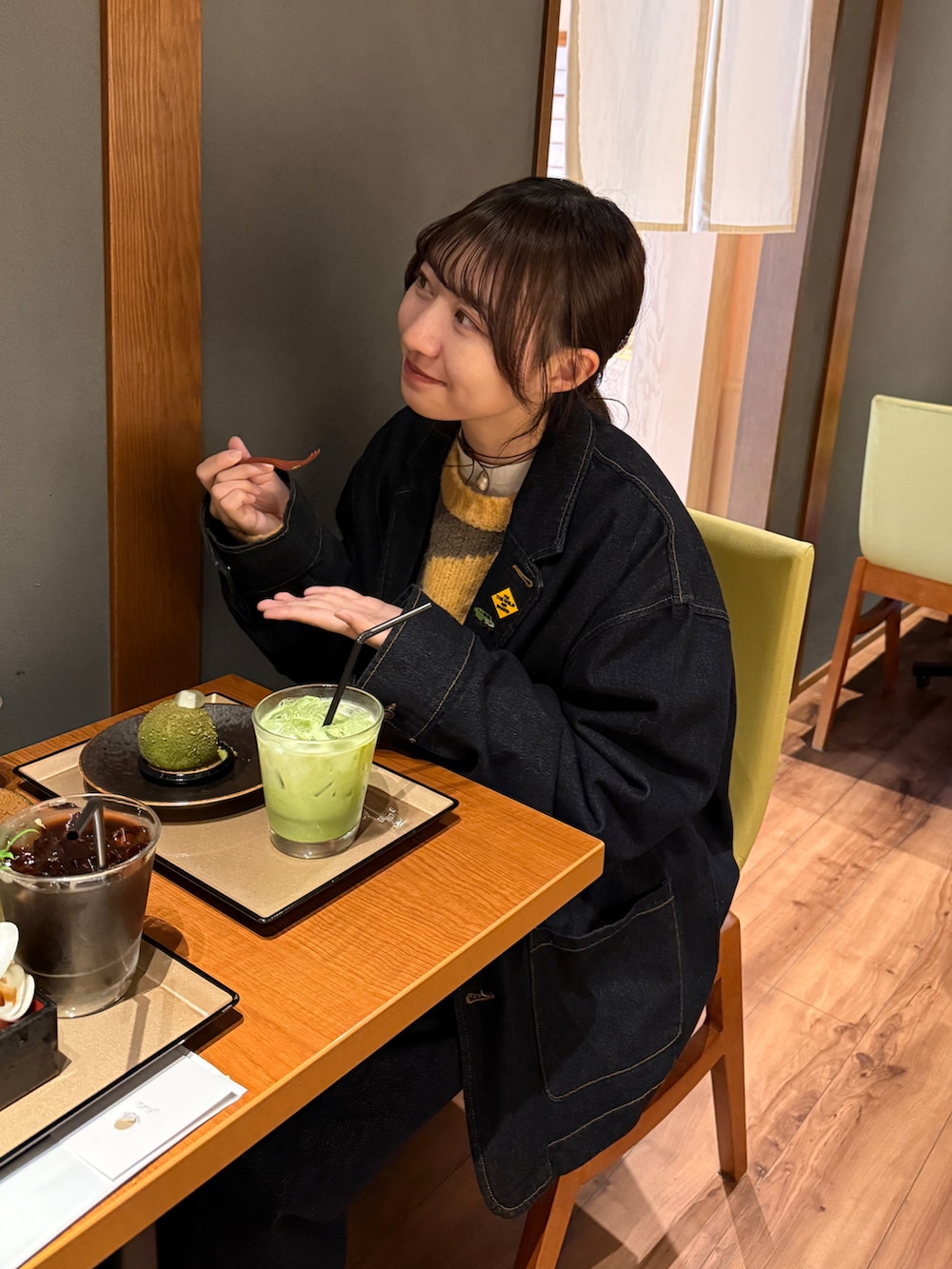 イエロー系のショルダーバッグ、ブルー系のデニムジャケット、ブルー系のデニムパンツを着用したレディースの秋コーディネートの2枚目の写真