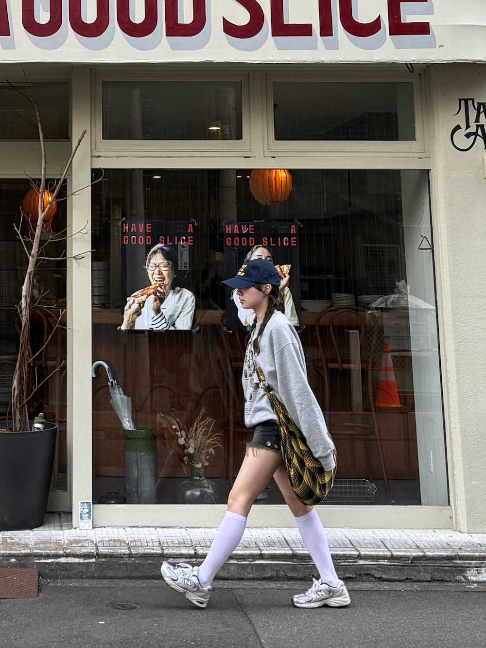 グレー系のスウェット、ブルー系のデニムパンツ、イエロー系のショルダーバッグを着用したレディースの秋コーディネートの4枚目の写真