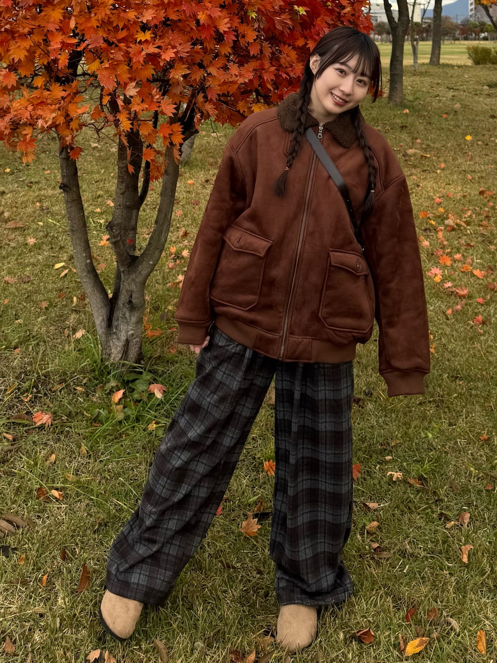 ブラウン系のムートンコート、ブルー系のパンツ、ブラウン系のサンダルを着用したレディースの秋コーディネートの2枚目の写真