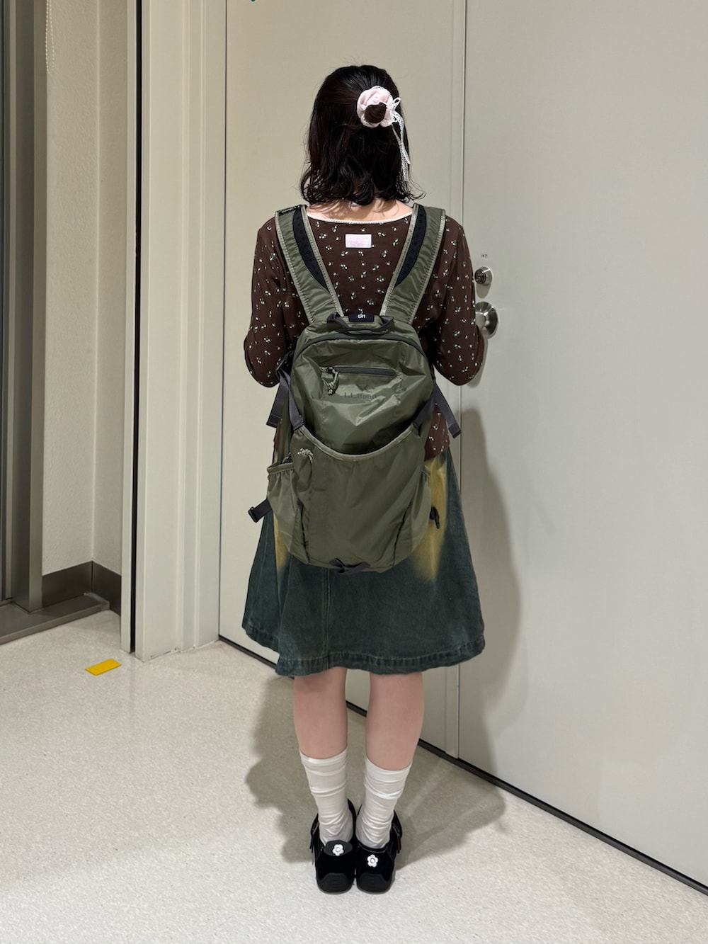 グリーン系のバックパック/リュック、ブラック系のスニーカー、ブラウン系のTシャツ/カットソーを着用したレディースの春コーディネートの2枚目の写真