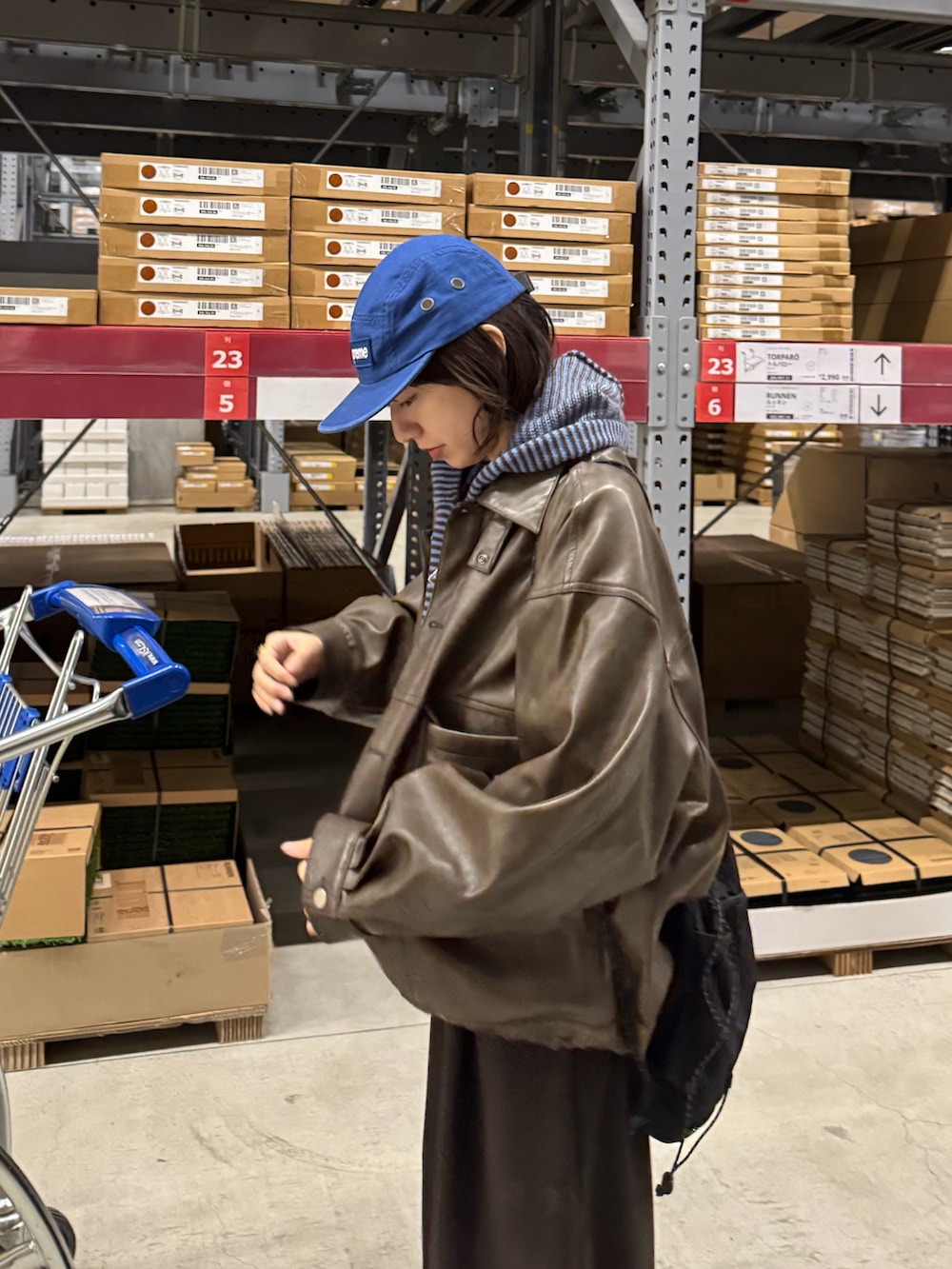 ブラック系のバックパック/リュック、ブラウン系のサンダル、ブルー系のパーカーを着用したレディースの冬コーディネートの2枚目の写真