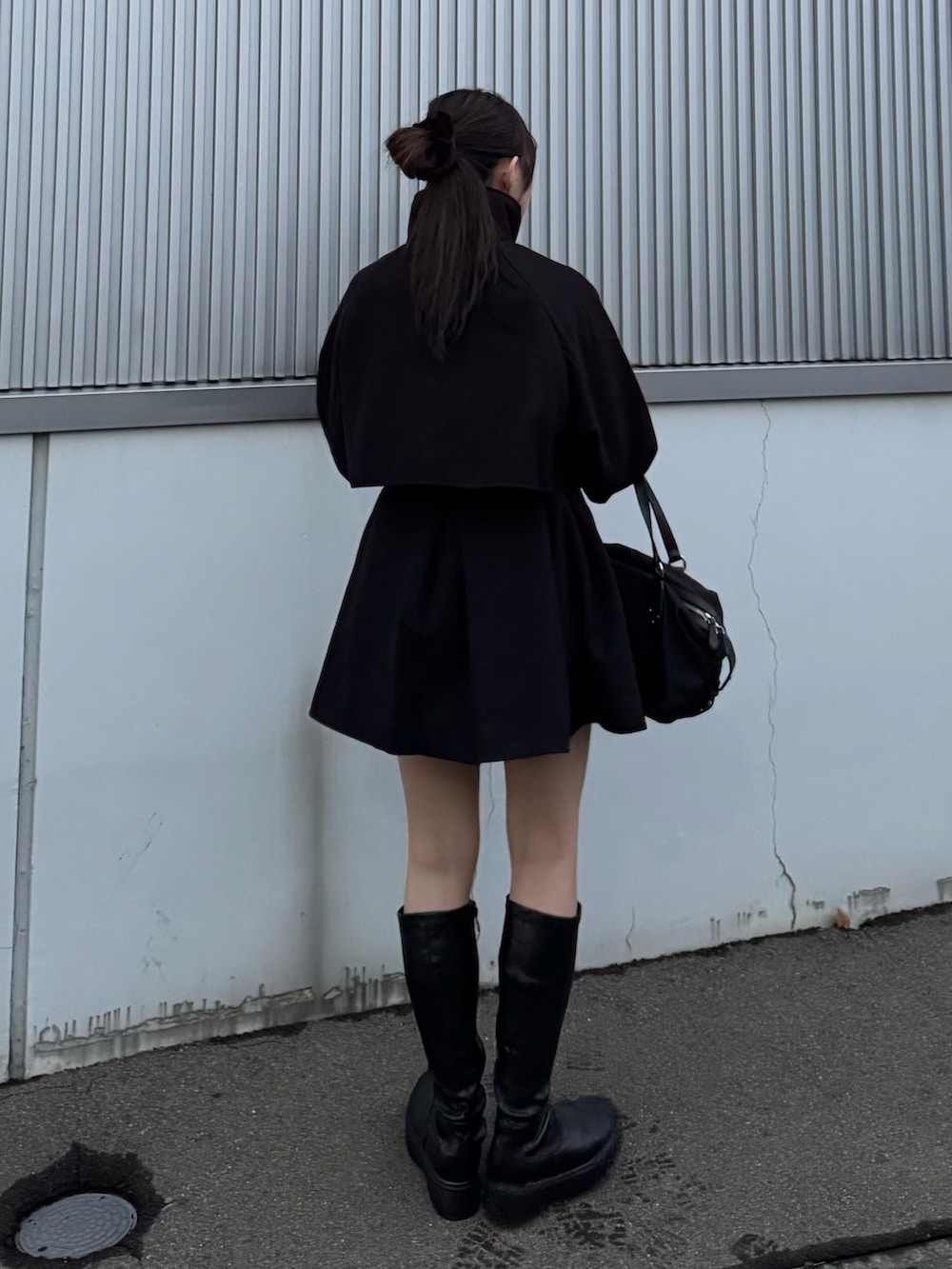 ブラック系のトレンチコート、ブラック系のその他パンツ、ホワイト系のニット/セーターを着用したレディースの秋コーディネートの3枚目の写真