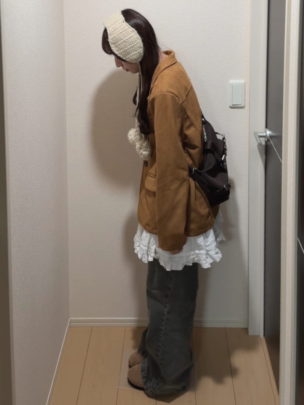 ブラウン系のテーラードジャケット、ホワイト系のワンピース、ブルー系のデニムパンツを着用したレディースの秋コーディネートの2枚目の写真