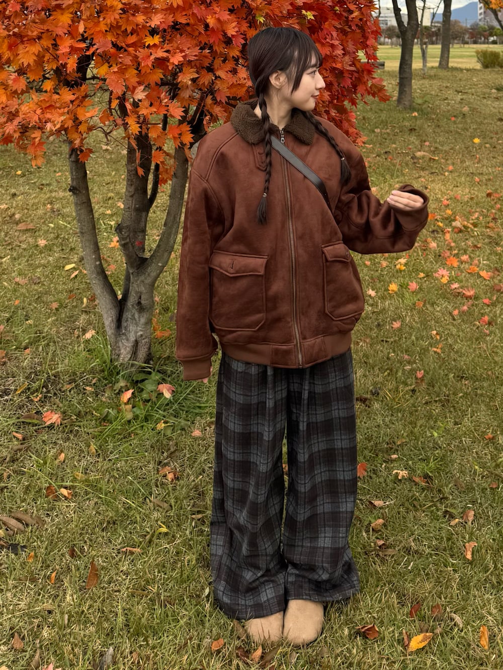 ブラウン系のムートンコート、ブルー系のパンツ、ブラウン系のサンダルを着用したレディースの秋コーディネートの3枚目の写真