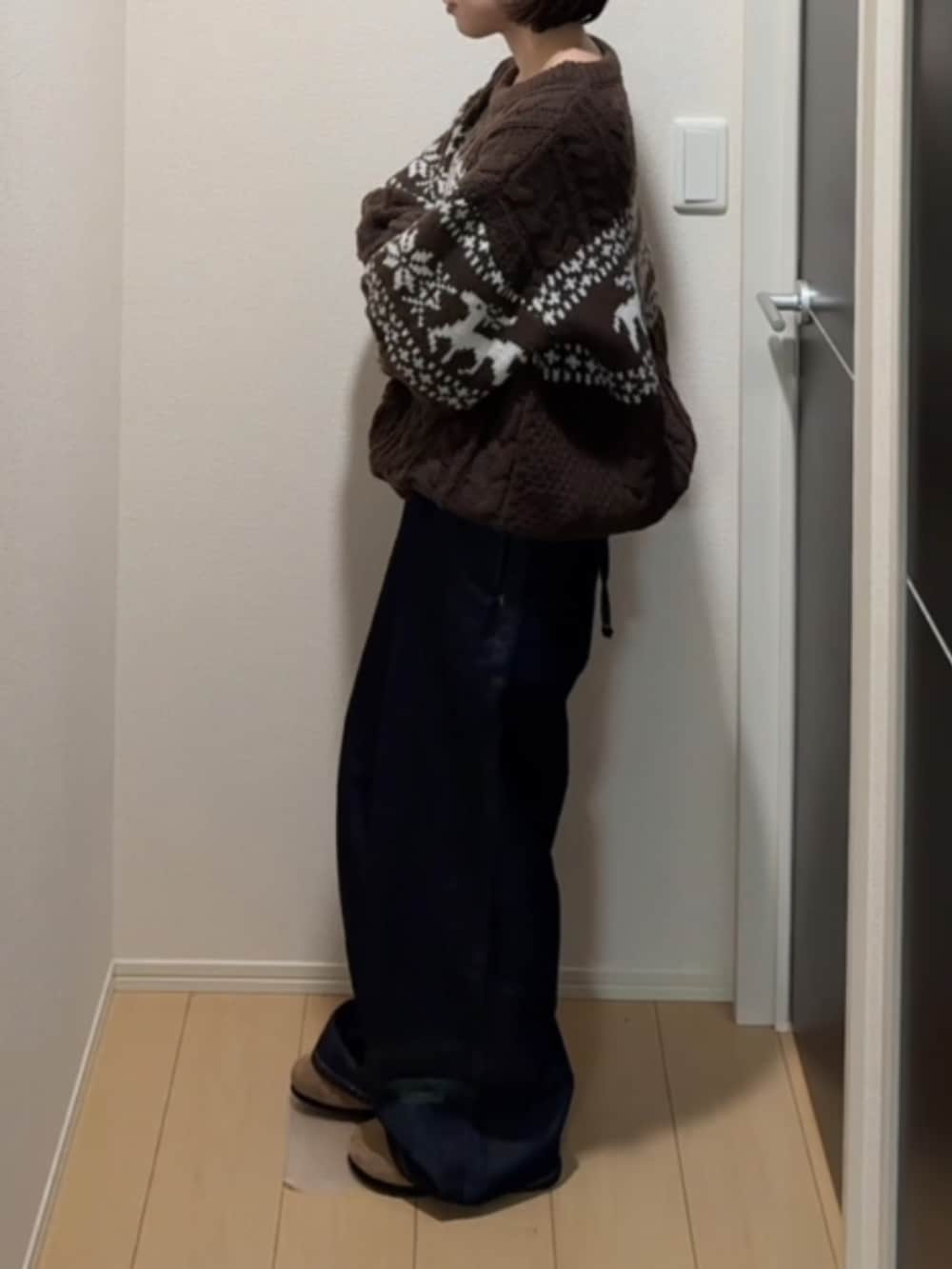 ブラウン系のニット/セーター、ブルー系のサロペット/オーバーオール、ブラウン系のサンダルを着用したレディースの冬コーディネートの2枚目の写真