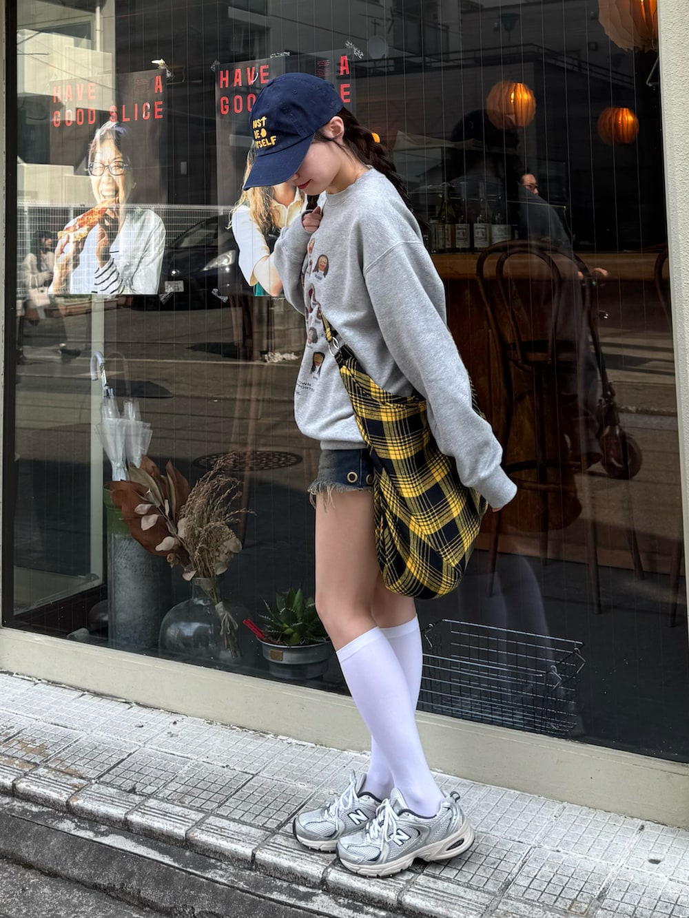 グレー系のスウェット、ブルー系のデニムパンツ、イエロー系のショルダーバッグを着用したレディースの秋コーディネートの3枚目の写真