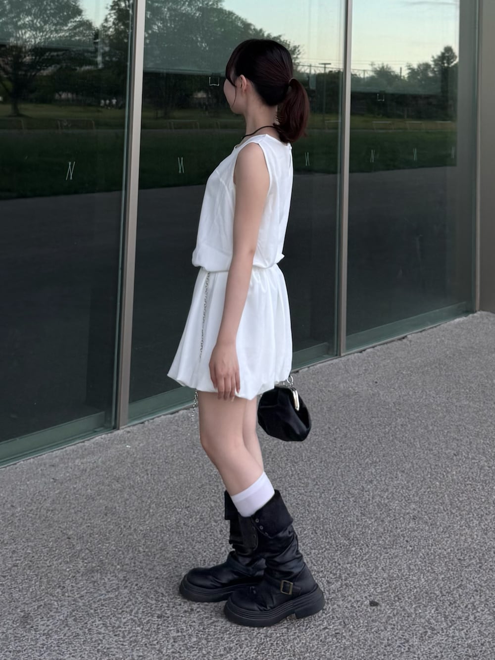 ホワイト系のワンピース、ブラック系のショルダーバッグを着用したレディースの夏コーディネートの2枚目の写真