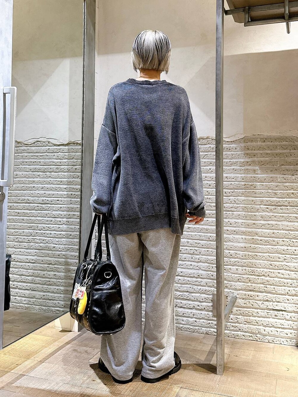 ブラック系のサンダル、ブルー系のデニムパンツ、ブラック系のトートバッグを着用したレディースの秋コーディネートの4枚目の写真