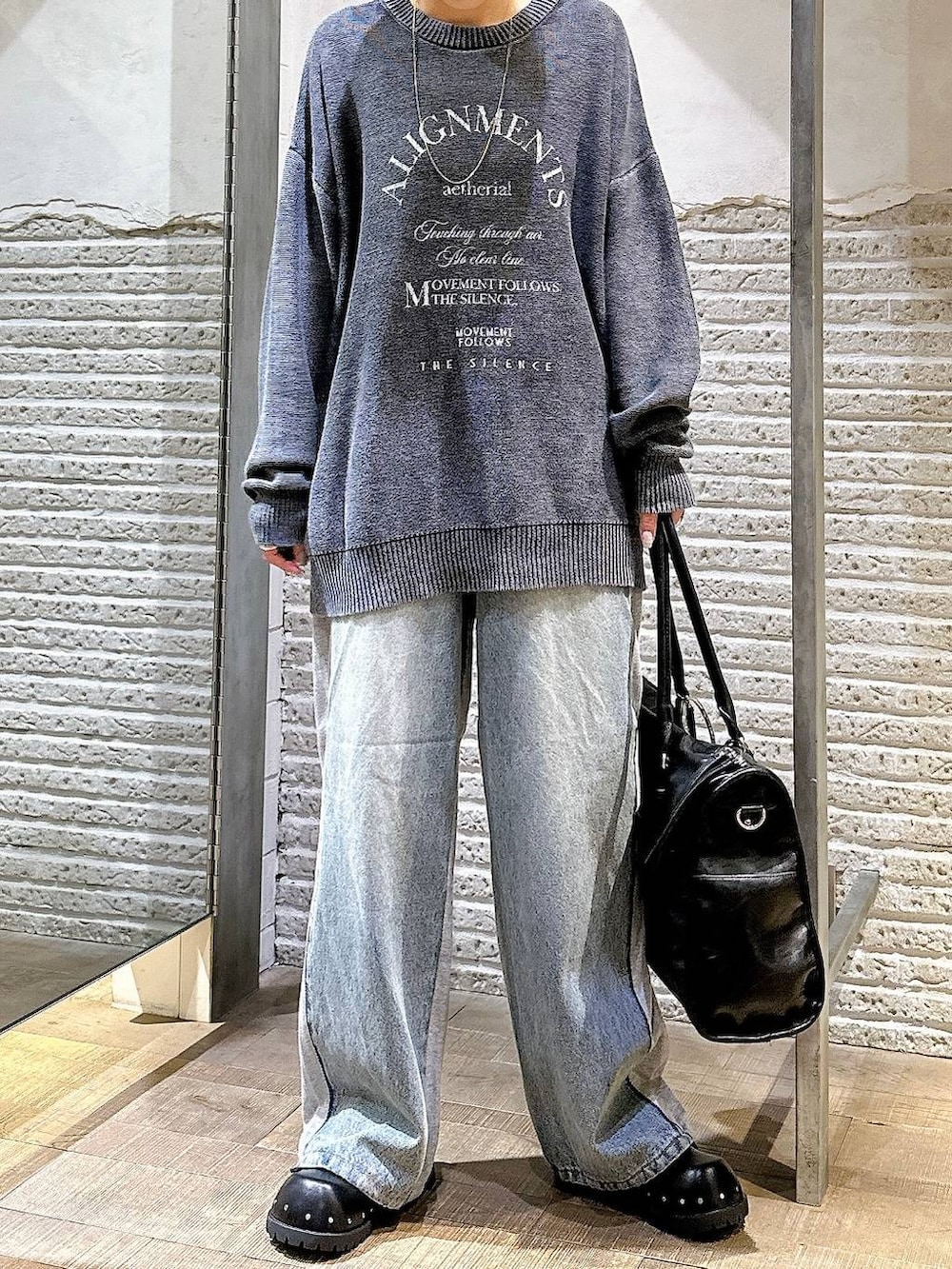 ブラック系のサンダル、ブルー系のデニムパンツ、ブラック系のトートバッグを着用したレディースの秋コーディネートの5枚目の写真