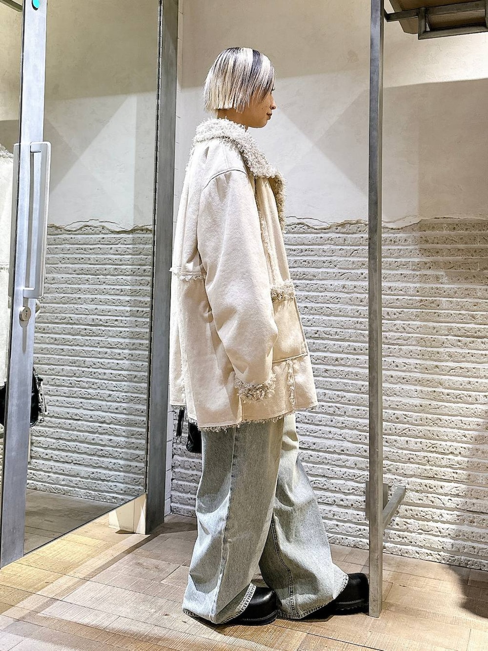 ブラウン系のニット/セーター、ブルー系のデニムパンツ、ブラック系のボストンバッグを着用したレディースの冬コーディネートの3枚目の写真