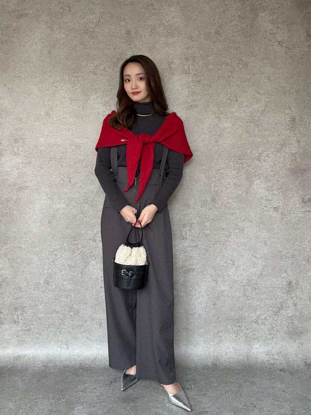 ブラック系のショルダーバッグ、ゴールド系のチョーカーを着用したレディースの冬コーディネートの2枚目の写真