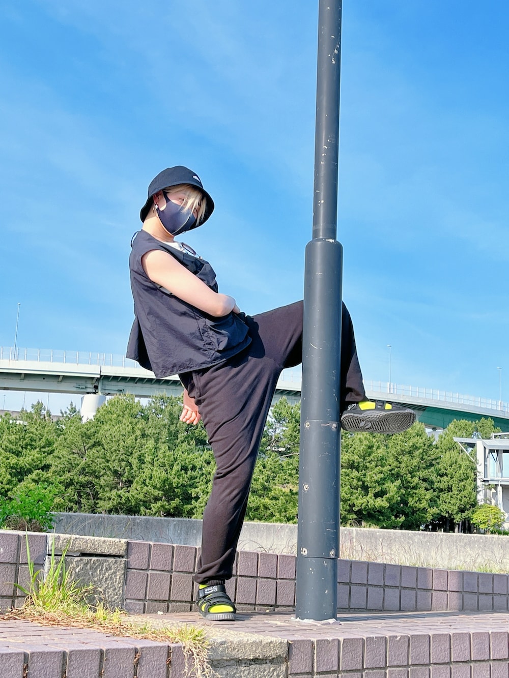 ブラック系のベスト、ブラック系のスウェットパンツ、ブラック系のサンダルを着用したレディースの春コーディネートの3枚目の写真