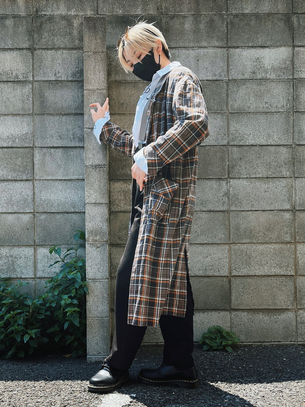 ブラウン系のノーカラーコート、ホワイト系のシャツ/ブラウス、ブラック系のサロペット/オーバーオールを着用したレディースの春コーディネートの2枚目の写真