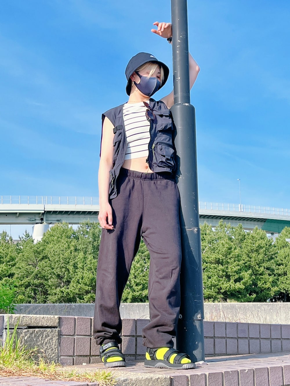 ブラック系のベスト、ブラック系のスウェットパンツ、ブラック系のサンダルを着用したレディースの春コーディネートの2枚目の写真