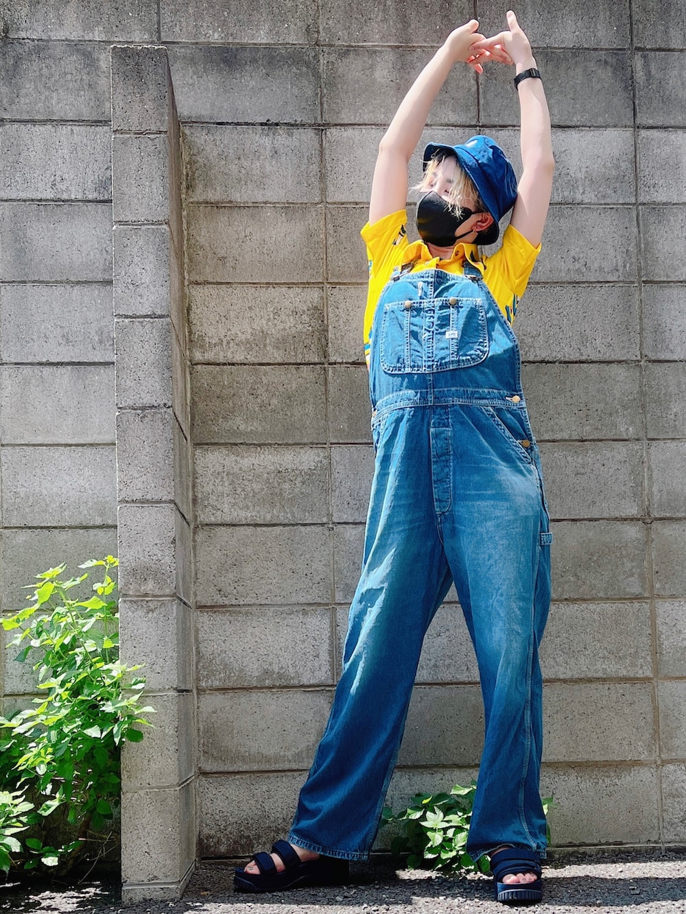 ブルー系のサロペット/オーバーオール、ブルー系のサンダル、イエロー系のシャツ/ブラウスを着用したレディースの夏コーディネートの3枚目の写真