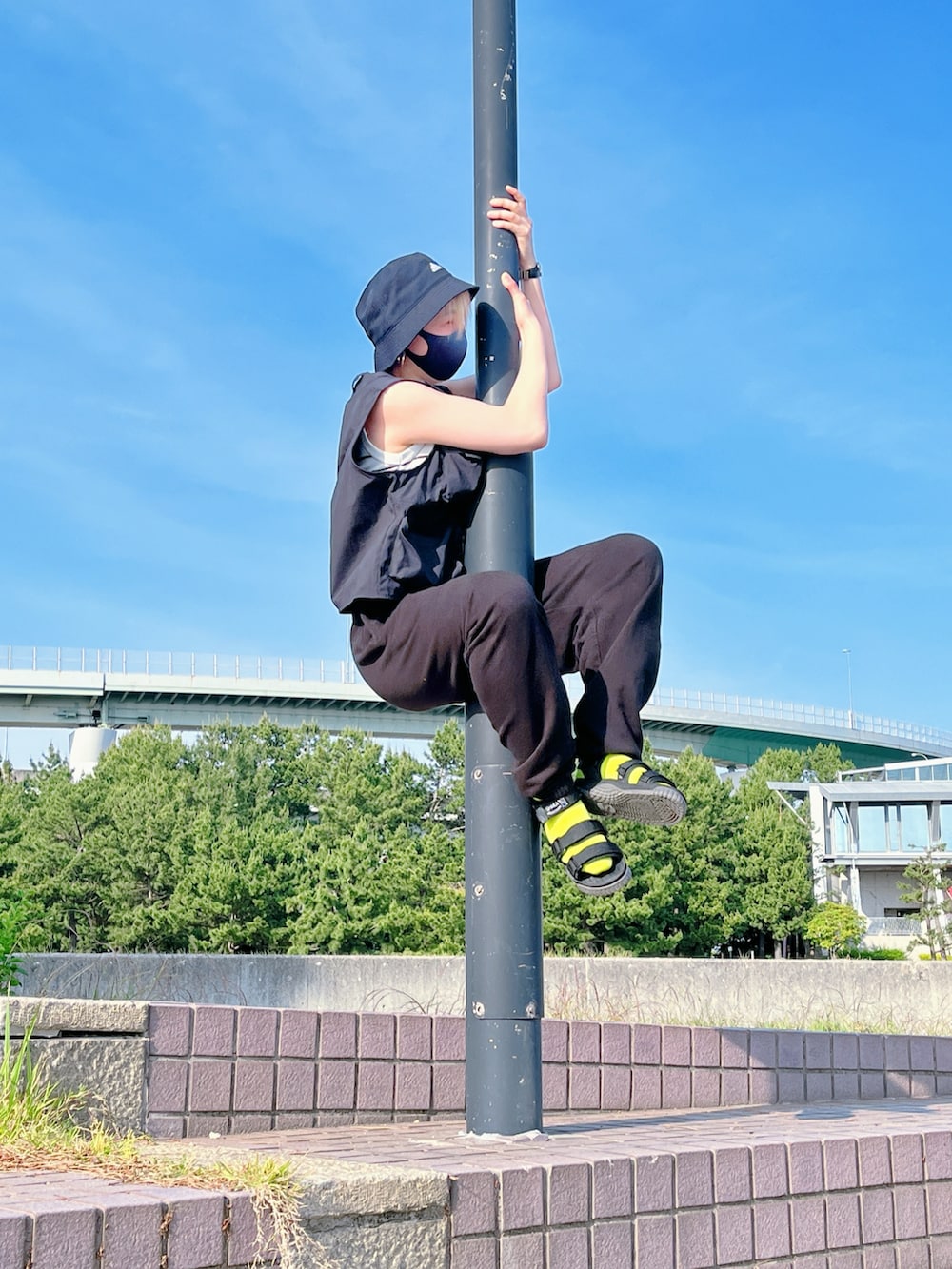 ブラック系のベスト、ブラック系のスウェットパンツ、ブラック系のサンダルを着用したレディースの春コーディネートの4枚目の写真