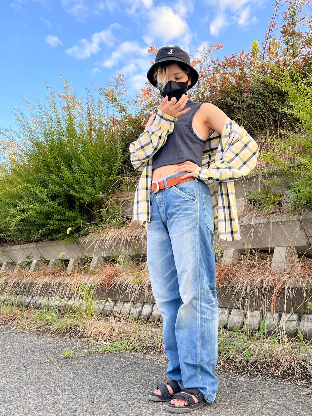 イエロー系のシャツ/ブラウス、ブラック系のタンクトップ、ブルー系のデニムパンツを着用したレディースの夏コーディネートの3枚目の写真