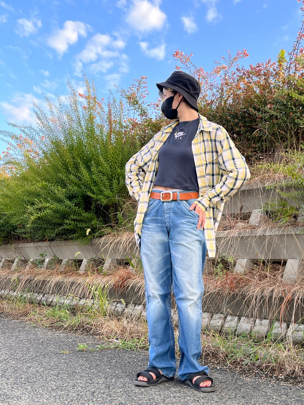 イエロー系のシャツ/ブラウス、ブラック系のタンクトップ、ブルー系のデニムパンツを着用したレディースの夏コーディネートの4枚目の写真