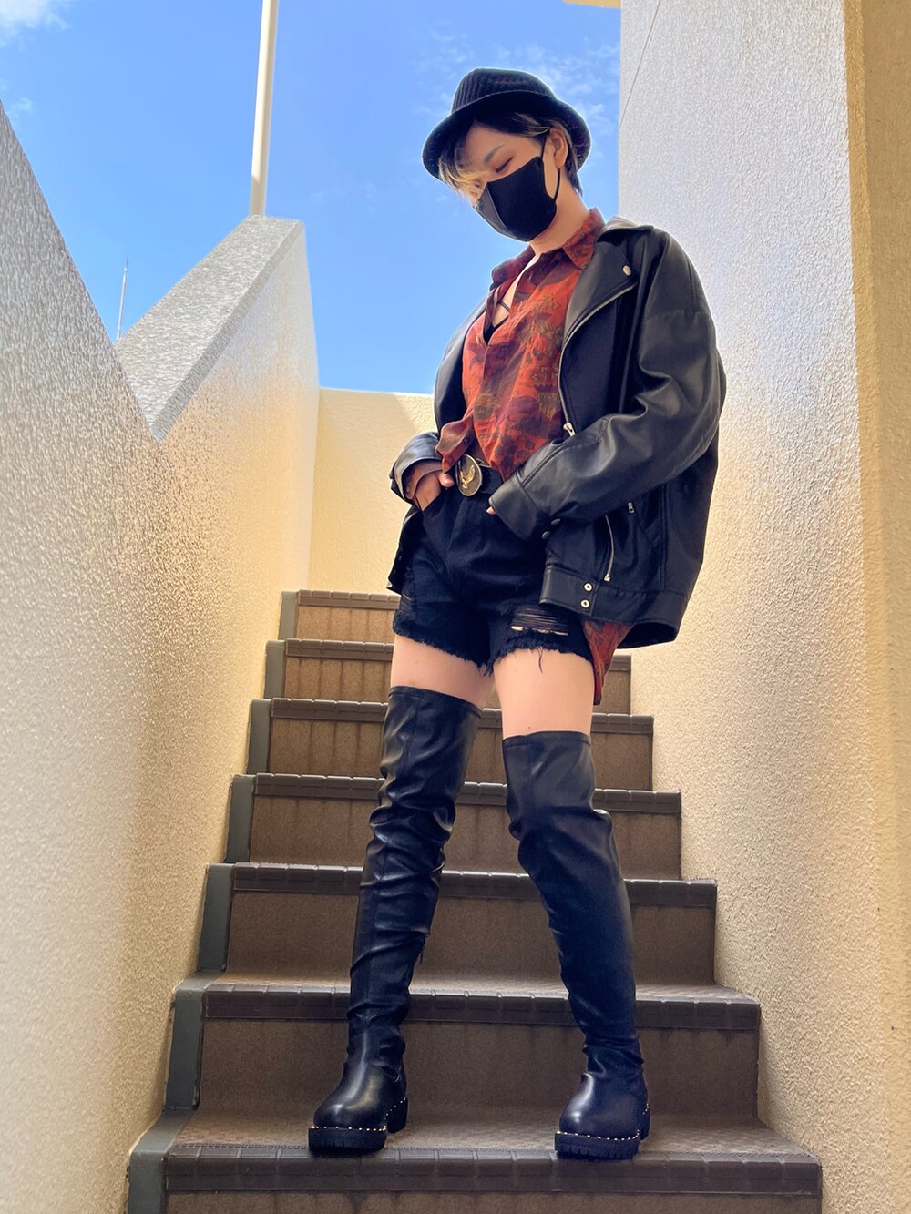 オレンジ系のシャツ/ブラウス、ブラック系のその他パンツ、ブラック系のブーツを着用したレディースの秋コーディネートの2枚目の写真