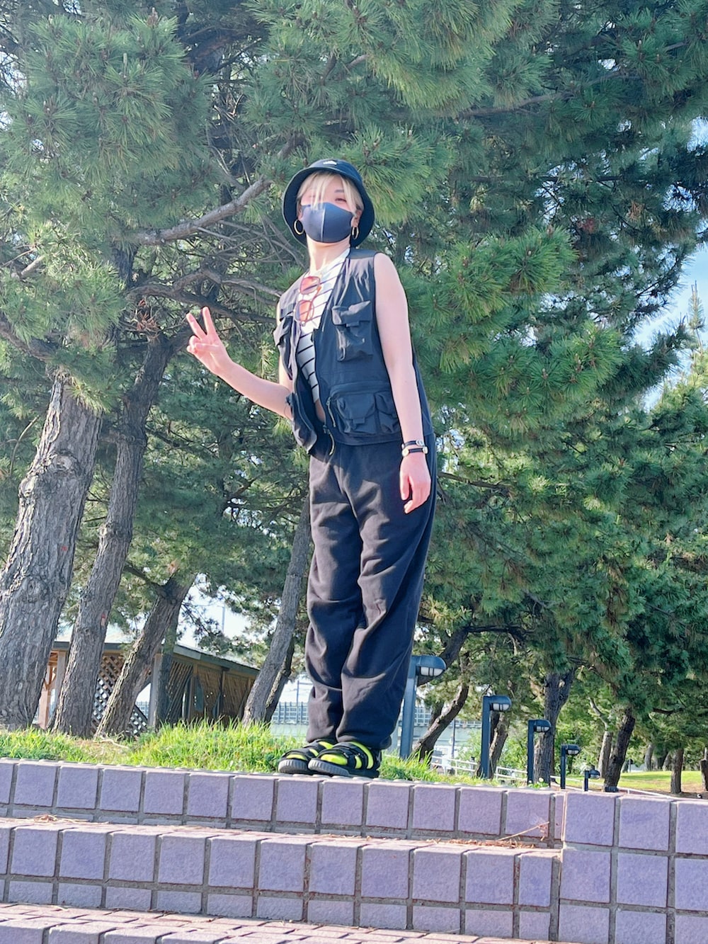 ブラック系のベスト、ブラック系のスウェットパンツ、ブラック系のサンダルを着用したレディースの春コーディネートの5枚目の写真