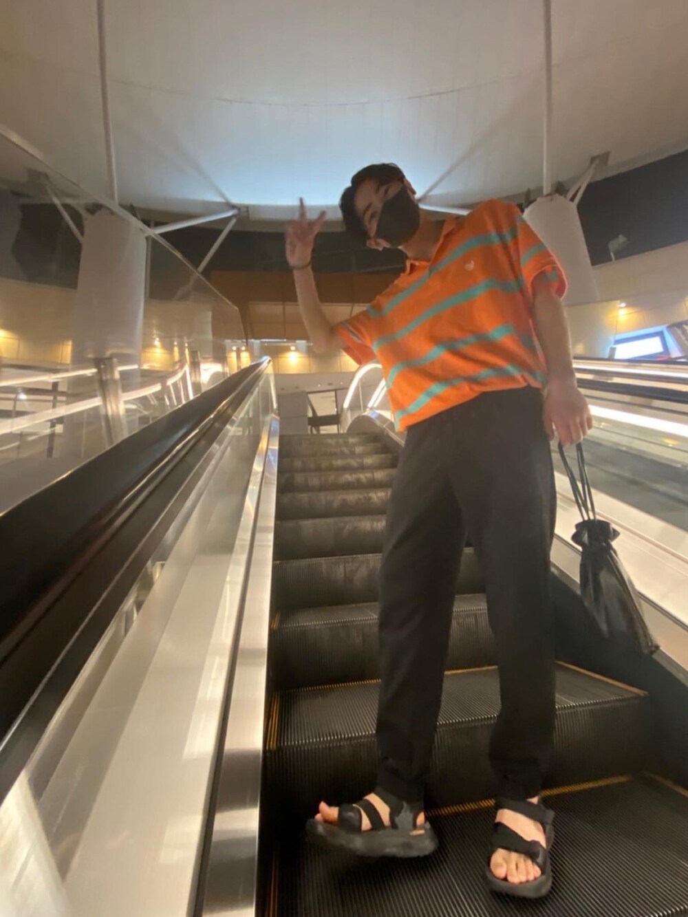 オレンジ系のポロシャツを着用したメンズの夏コーディネートの2枚目の写真