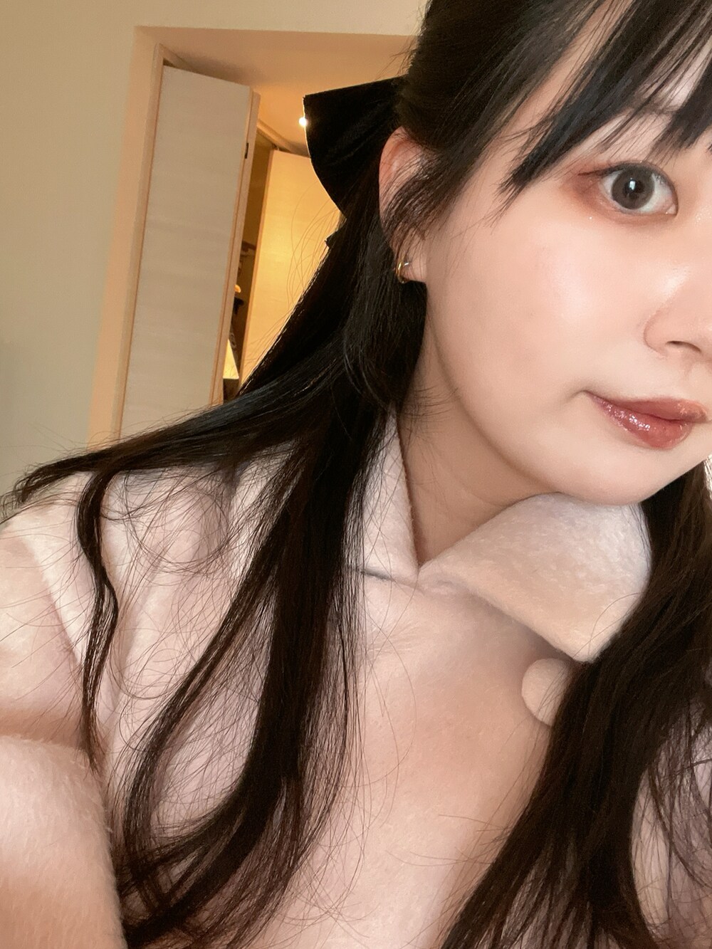 ピンク系のステンカラーコート、ブラック系のブーツ、ブラック系のバレッタ/ヘアクリップを着用したレディースの冬コーディネートの3枚目の写真