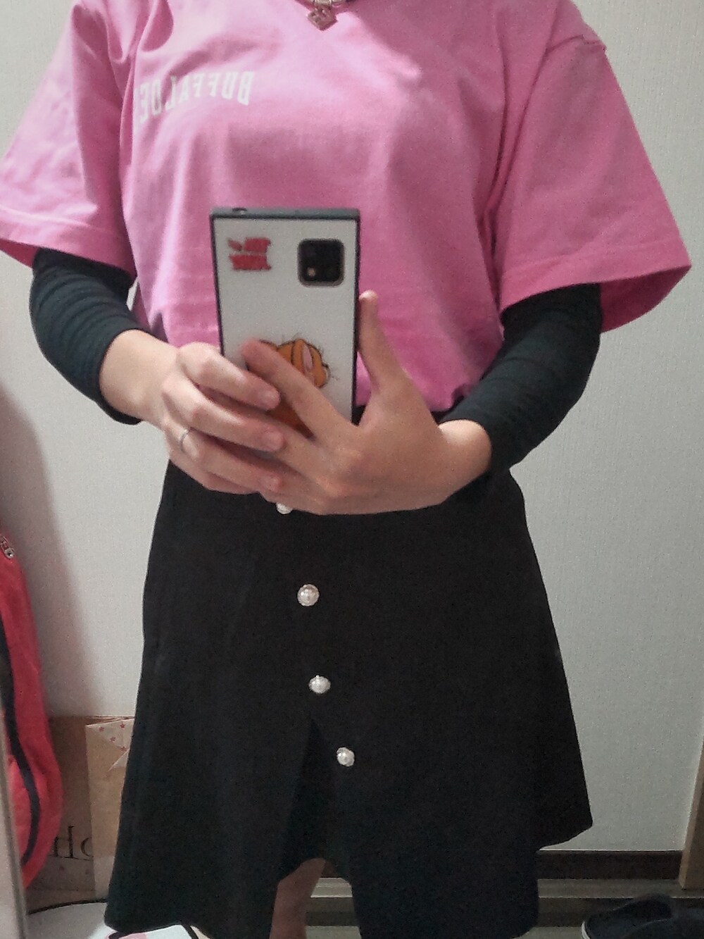 ピンク系のTシャツ/カットソー、ブラック系のスカートを着用したレディースの春コーディネートの3枚目の写真