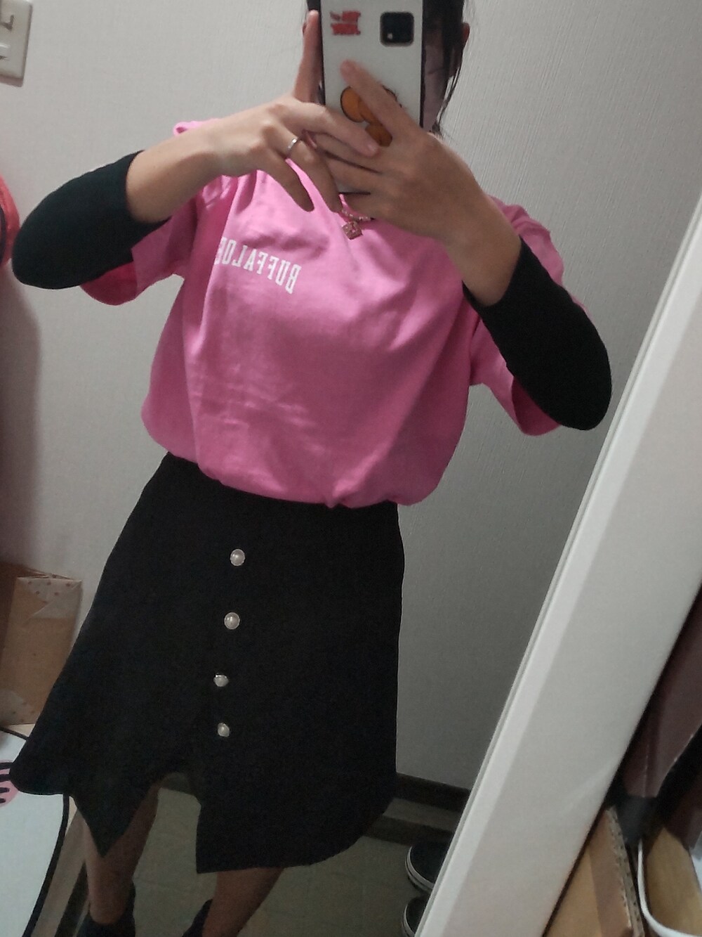ピンク系のTシャツ/カットソー、ブラック系のスカートを着用したレディースの春コーディネートの2枚目の写真