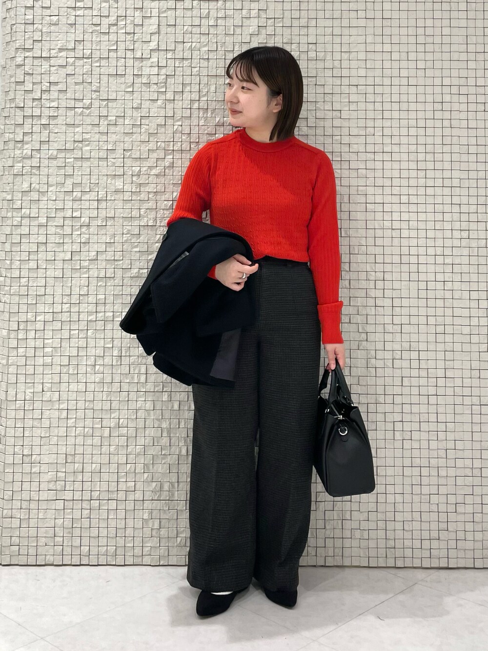 レッド系のニット/セーター、ブラック系のノーカラーコート、グレー系のその他パンツを着用したレディースの冬コーディネートの4枚目の写真
