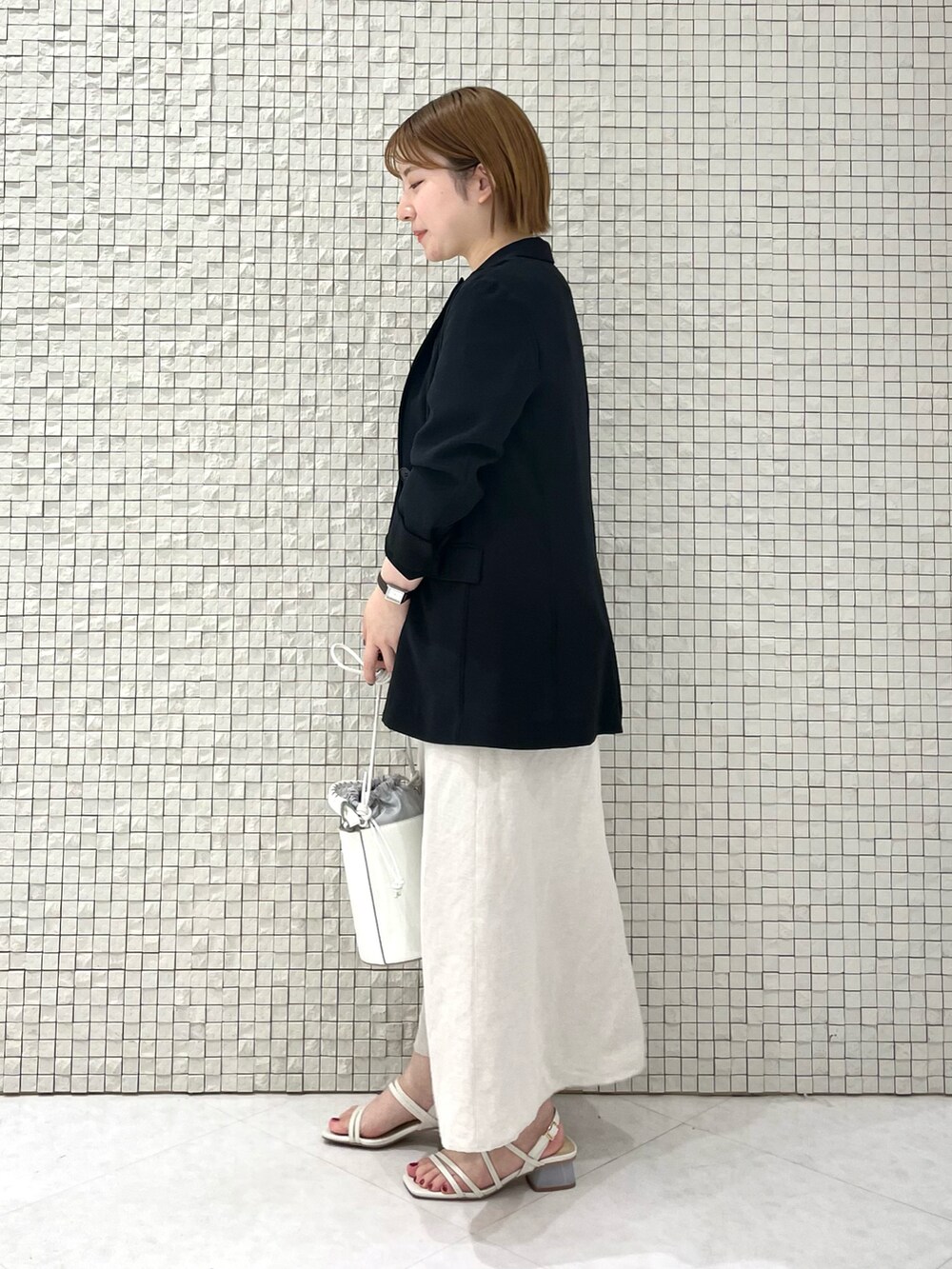 グレー系のTシャツ/カットソー、ベージュ系のスカート、ホワイト系のショルダーバッグを着用したレディースの夏コーディネートの2枚目の写真