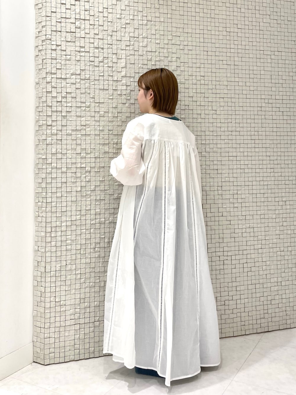 ホワイト系のタンクトップ、ホワイト系のワンピース、ブルー系のデニムパンツを着用したレディースの夏コーディネートの2枚目の写真