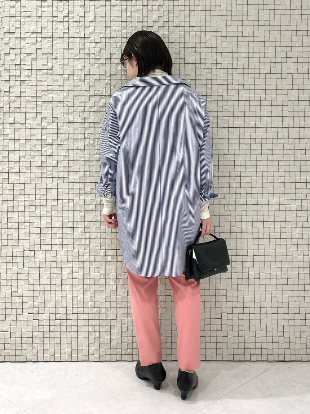 ブルー系のシャツ/ブラウス、ホワイト系のニット/セーター、ピンク系のその他パンツを着用したレディースの秋コーディネートの3枚目の写真