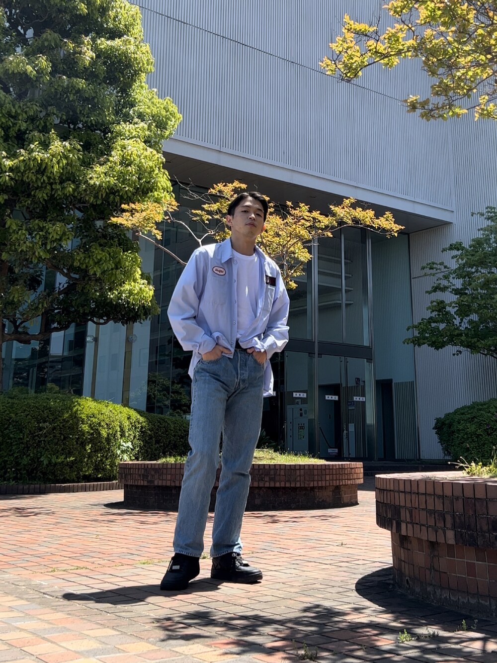 ブルー系のデニムパンツ、ブルー系のシャツ/ブラウス、ホワイト系のTシャツ/カットソーを着用したメンズの春コーディネートの2枚目の写真