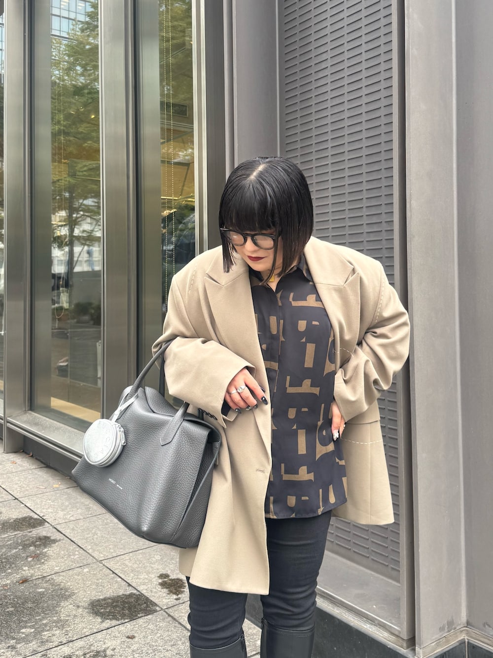 グレー系のトートバッグ、シルバー系のその他小物を着用したレディースの秋コーディネートの2枚目の写真