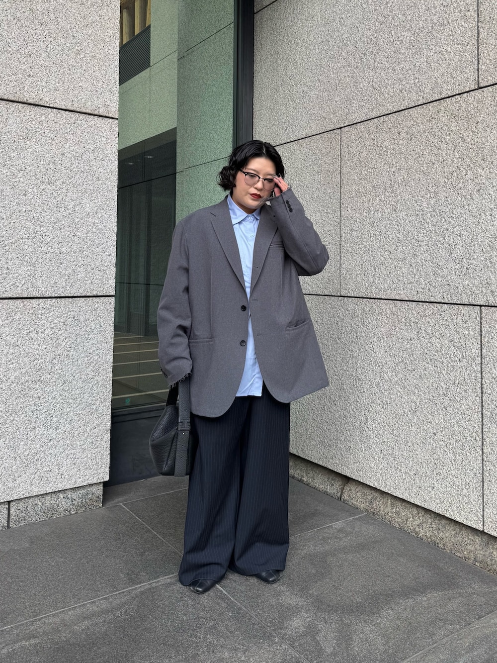 ブラック系のトートバッグを着用したレディースの冬コーディネートの2枚目の写真