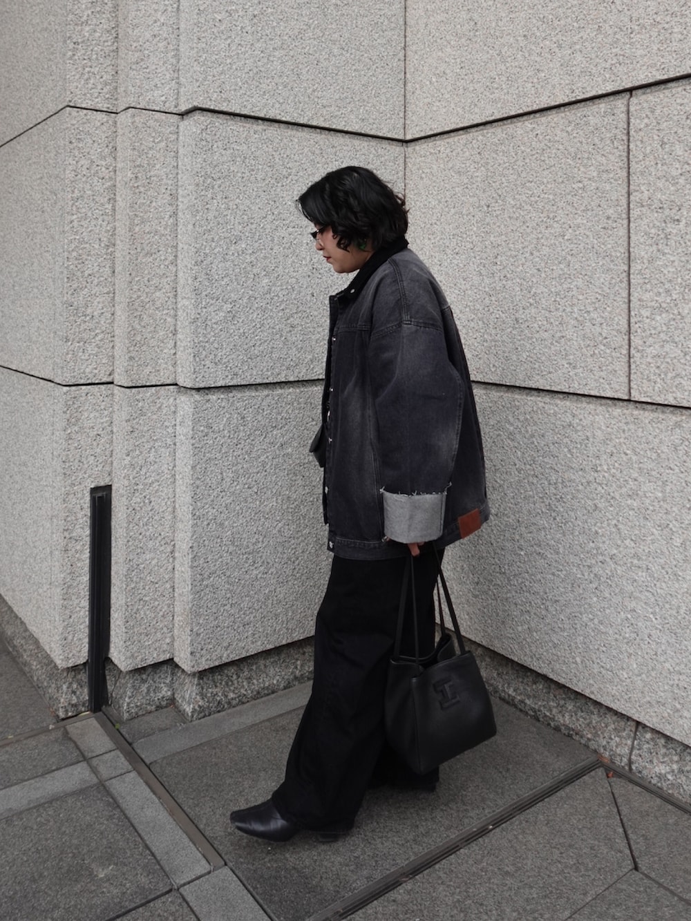 ブラック系のトートバッグを着用したレディースの春コーディネートの2枚目の写真