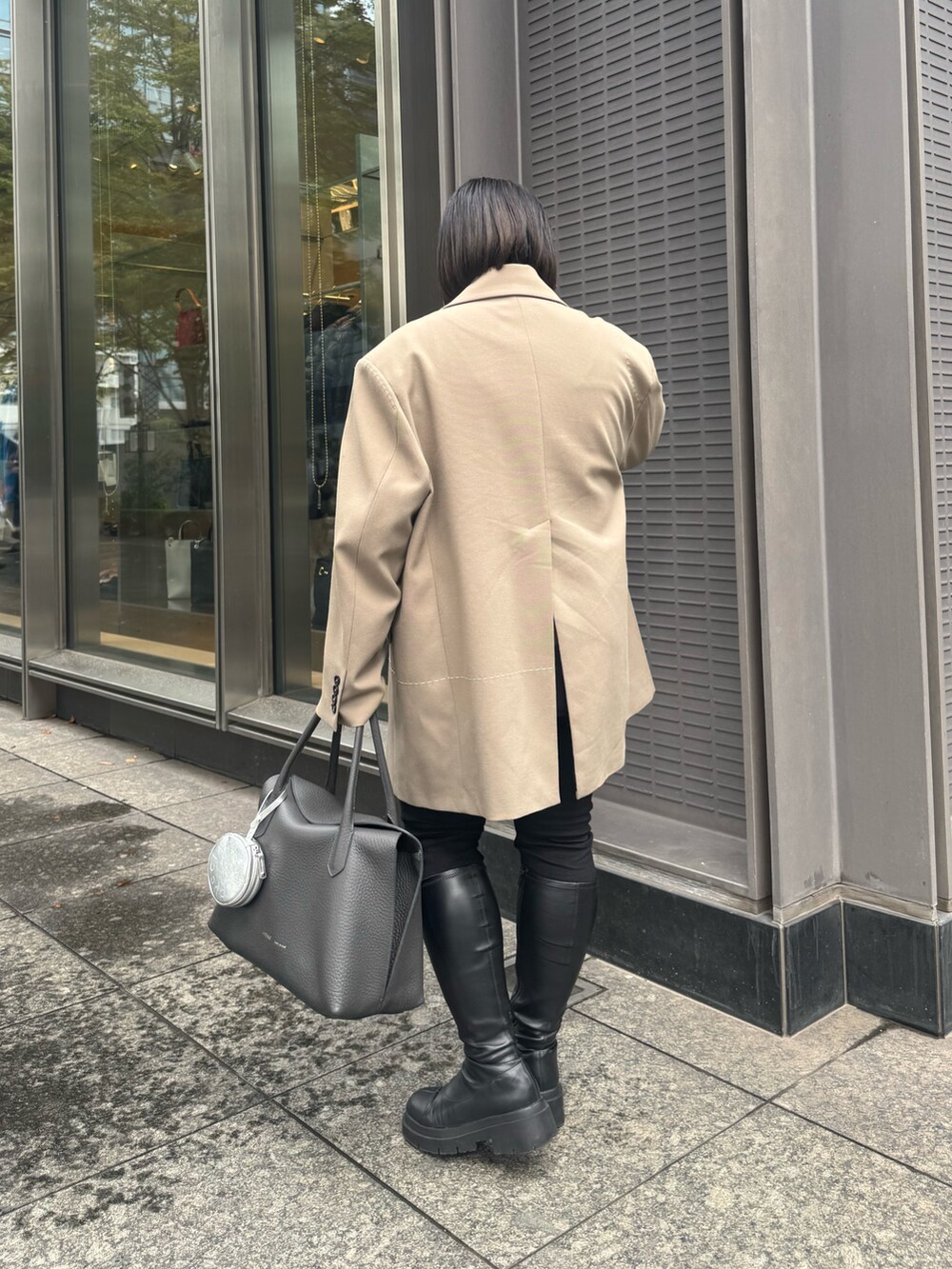 グレー系のトートバッグ、シルバー系のその他小物を着用したレディースの秋コーディネートの3枚目の写真