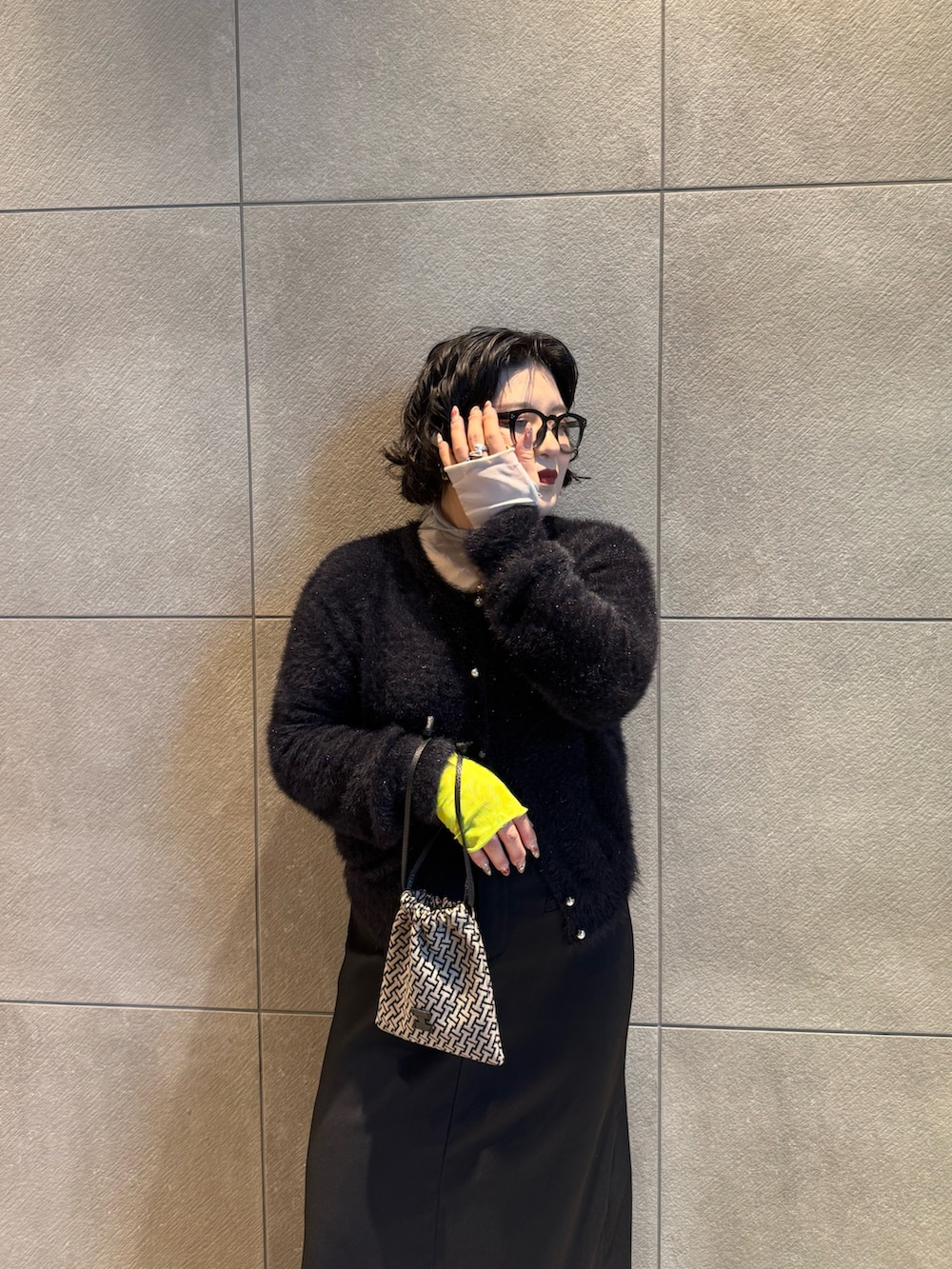 ブラック系のポーチを着用したレディースの冬コーディネートの2枚目の写真