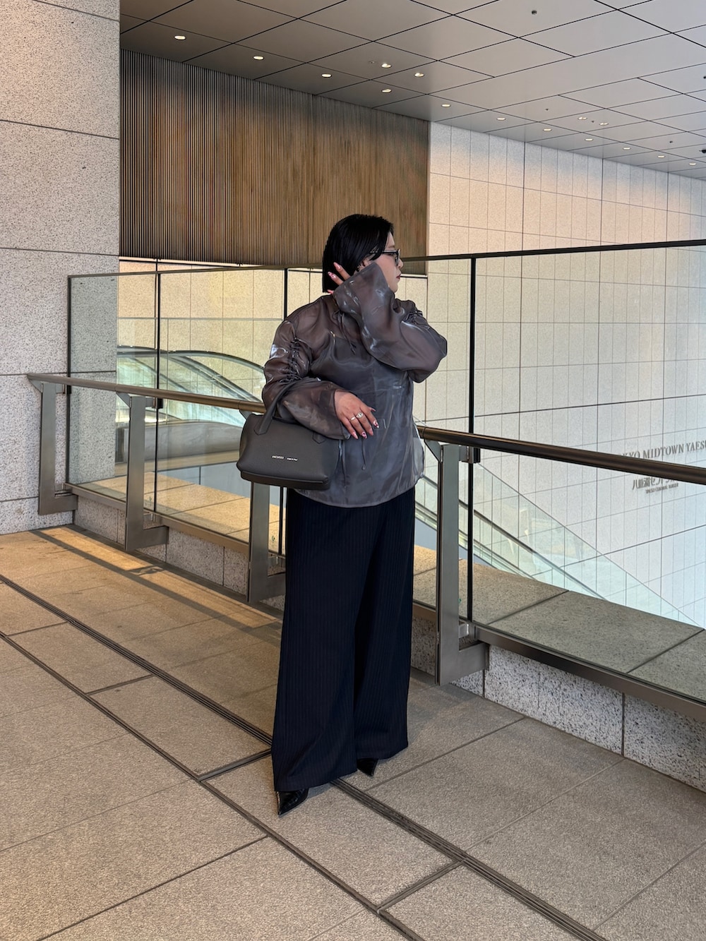 グレー系のトートバッグを着用したレディースの春コーディネートの2枚目の写真