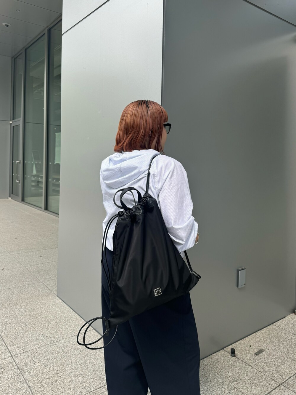 ブラック系のバックパック/リュックを着用したレディースの夏コーディネートの2枚目の写真