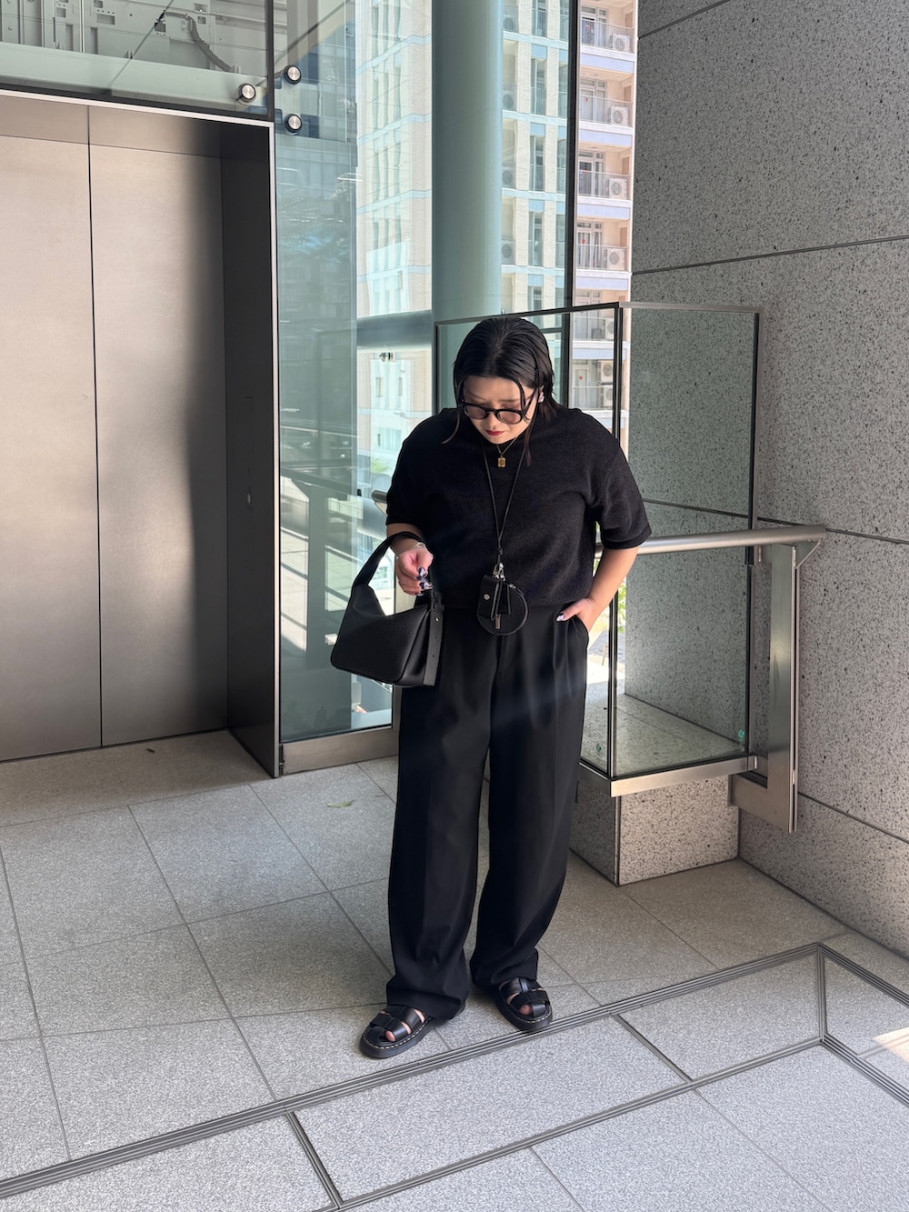 ブラック系のトートバッグを着用したレディースの春コーディネートの3枚目の写真