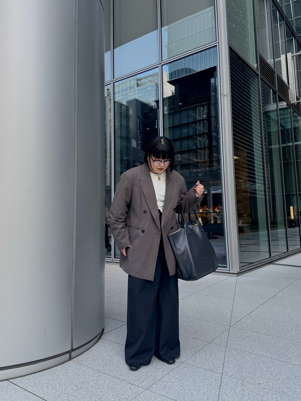 ブルー系のトートバッグを着用したレディースの秋コーディネートの3枚目の写真