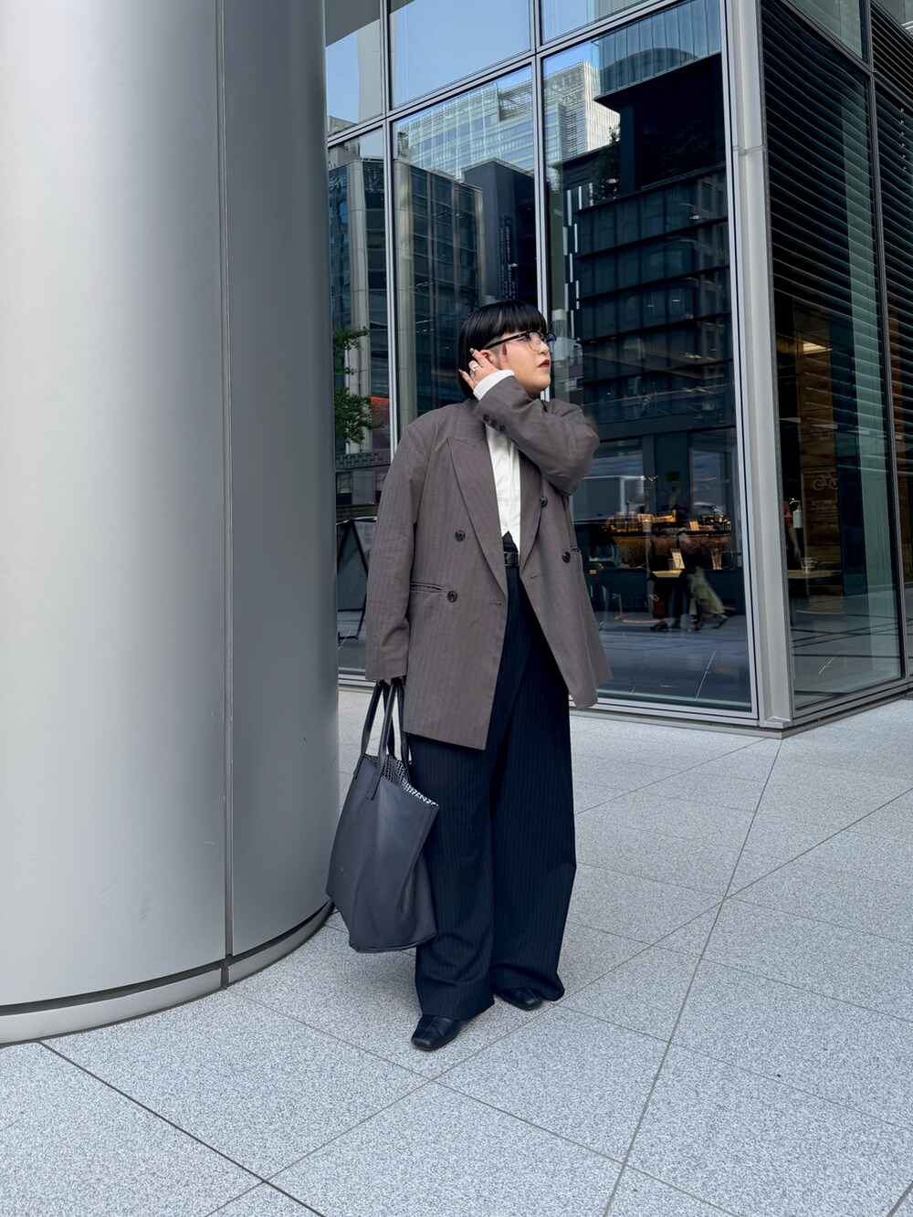 ブルー系のトートバッグを着用したレディースの秋コーディネートの2枚目の写真