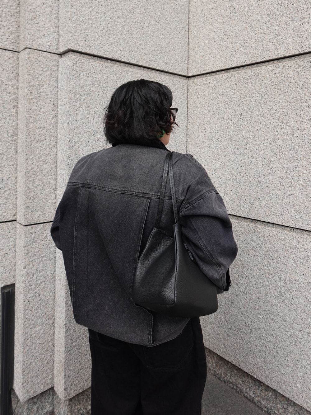 ブラック系のトートバッグを着用したレディースの春コーディネートの3枚目の写真